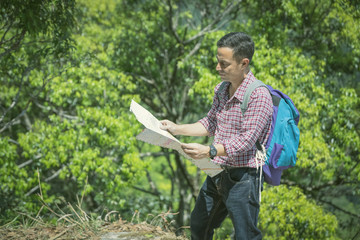 Backpacker looking at map in forest.