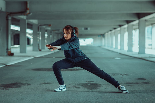 Young woman stretching legs before jogging