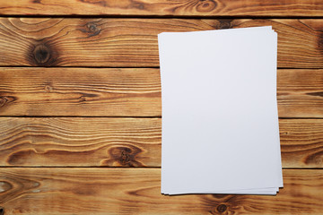 White business card on wooden table. Blank portrait A4.