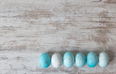 Easter background with eggs on a white wooden table. View from above