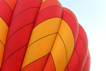 bright orange and yellow hot air balloon against a clear blue sky