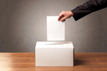 Ballot box with person casting vote on blank voting slip, grungy background