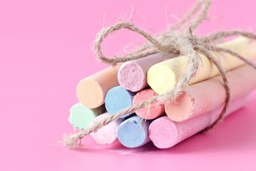 Color chalk crayon on pink background