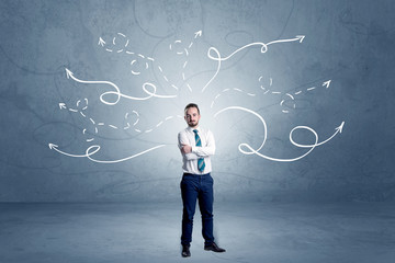 Elegant businessman choosing between directions with winding drawn arrows around 
