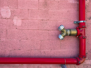 Fire hydrant red color on the wall of an industrial building..Copy space