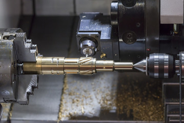 The CNC lathe machine cutting the brass shaft  part  by milling spindle.