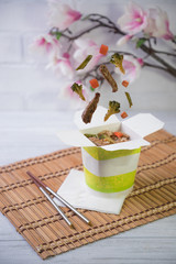 Levitating asian food. Levitating vegetables and meat. broccoli, sweet pepper, carrots and asparagus in flight.