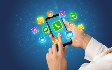 Female hand using smartphone with 3D shiny starlike application icons around
