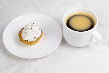 cupcake with cream decorated with chocolate chips  and coffee cup concrete background