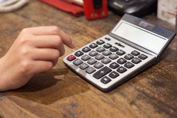 A women hand with calculator on business table.
