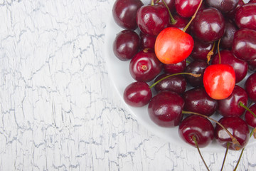 Various summer Fresh Cherry in a bowl on rustic wooden table. Antioxidants, detox diet, organic fruits. Top view. Berries