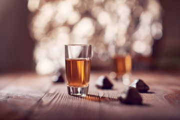 Glass of whiskey on wooden background blurred background,