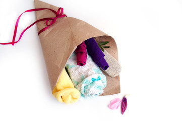 bath accessories are stacked in a brown paper bag covered with a red ribbon, a gift set for a girl