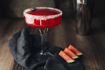 Red watermelon margarita cocktail on vintage wooden background