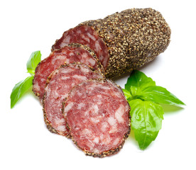 Dried organic salami sausage covered with pepper on white background