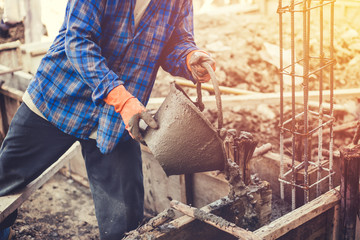 mason or plasterer pour construction cement on floor.