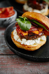 Burgers with grilled beef patties, cream cheese and spinach on classical bun.