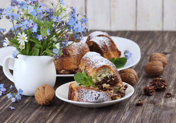 Marble biscuit and flowers on a wooden background