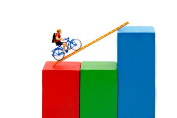 Miniature people: Traveler riding bicycle on wood ladder with growth graph, Concept of the path to...