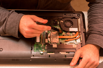 master cleans dust in laptop