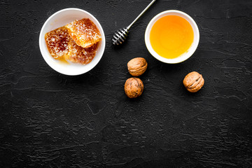 Fresh honey as dessert. Honey in bowl, honeycomb, nuts on black table top view copy space