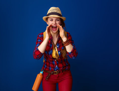 smiling woman hiker shouting through megaphone shaped hands