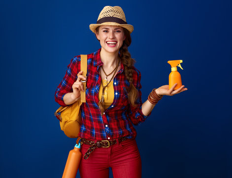 happy fit woman hiker isolated on blue background showing SPF