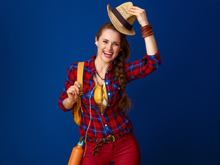 tourist woman with headphones listening to music and rising hat