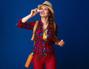 fit traveller woman isolated on blue using nasal drops