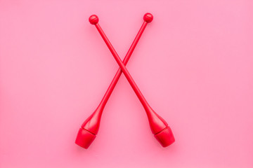 Maces for rhythmic gymnastics on pink background top view copy space