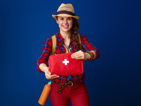 smiling healthy traveller woman showing first-aid kit