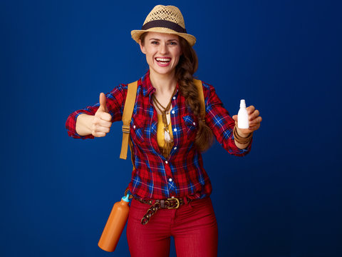 woman hiker isolated on blue with nasal drops showing thumbs up