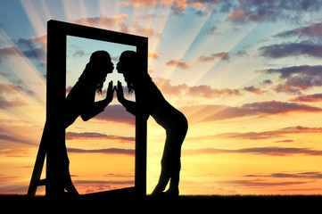 Woman is kissing her reflection in the mirror