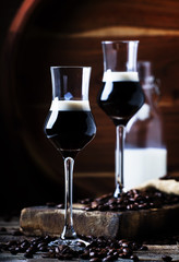 Two-layer cocktail with coffee liqueur, vintage wood background, selective focus