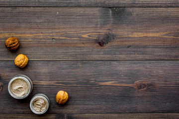 organic scrub with walnut for homemade spa on wooden background top view mockup
