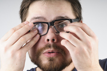 Shocked man with broken glasses on his face