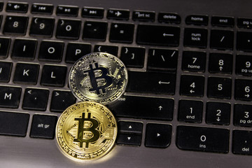 Golden and silver bitcoins on laptop keyboard