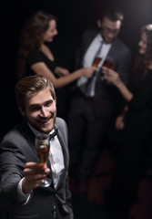 stylish young man standing with a glass of champagne.