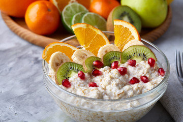 Breakfast still life with oatmeal porridge, fruits and coffee cup, top view, selective focus, shallow depth of field.