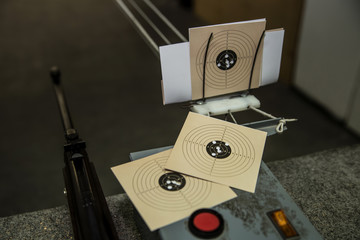 Air gun and three targets with bullet holes in it at shooting range