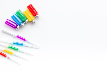 Syringe with colored drug. Injection concept on white background top view copy space