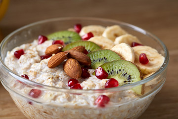 Breakfast still life with oatmeal porridge and fruits, top view, selective focus, shallow depth of field.