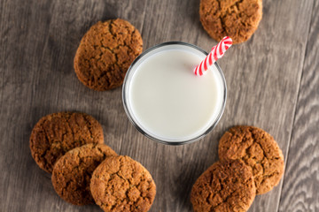Cookies and a glass of milk on a wooden table. Chocolate toned