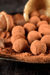 Chocolate truffles covered with cacao powder on a black plate