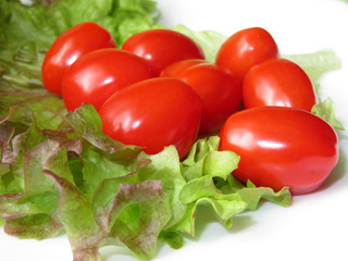Fresh cherry tomatoes on green lettuce leaf
