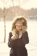 Pretty woman drinking coffee in cold weather