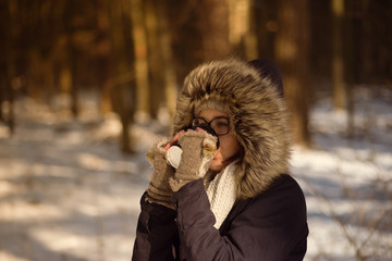 Pretty woman drinking coffee in cold weather