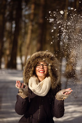 Pretty woman playing with snow