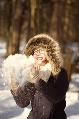 Pretty woman playing with snow