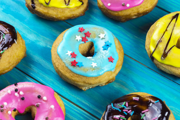 Bright and colorful homemade donuts on a wooden background
